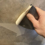 Scraping outer layer of wallpaper enough to get a grip on with fingers.